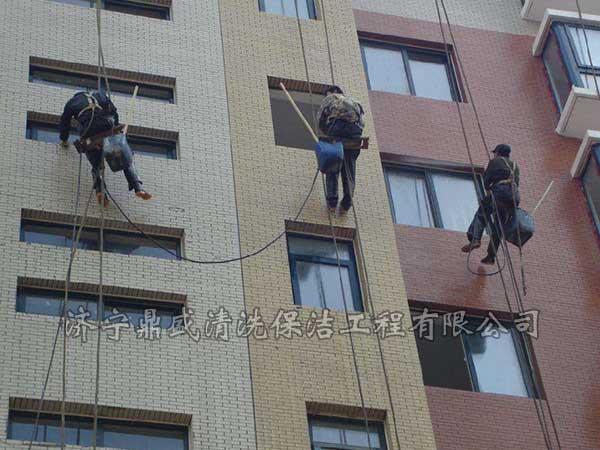 在楼顶架设吊篮将工人运送到指定位置进行施工操作